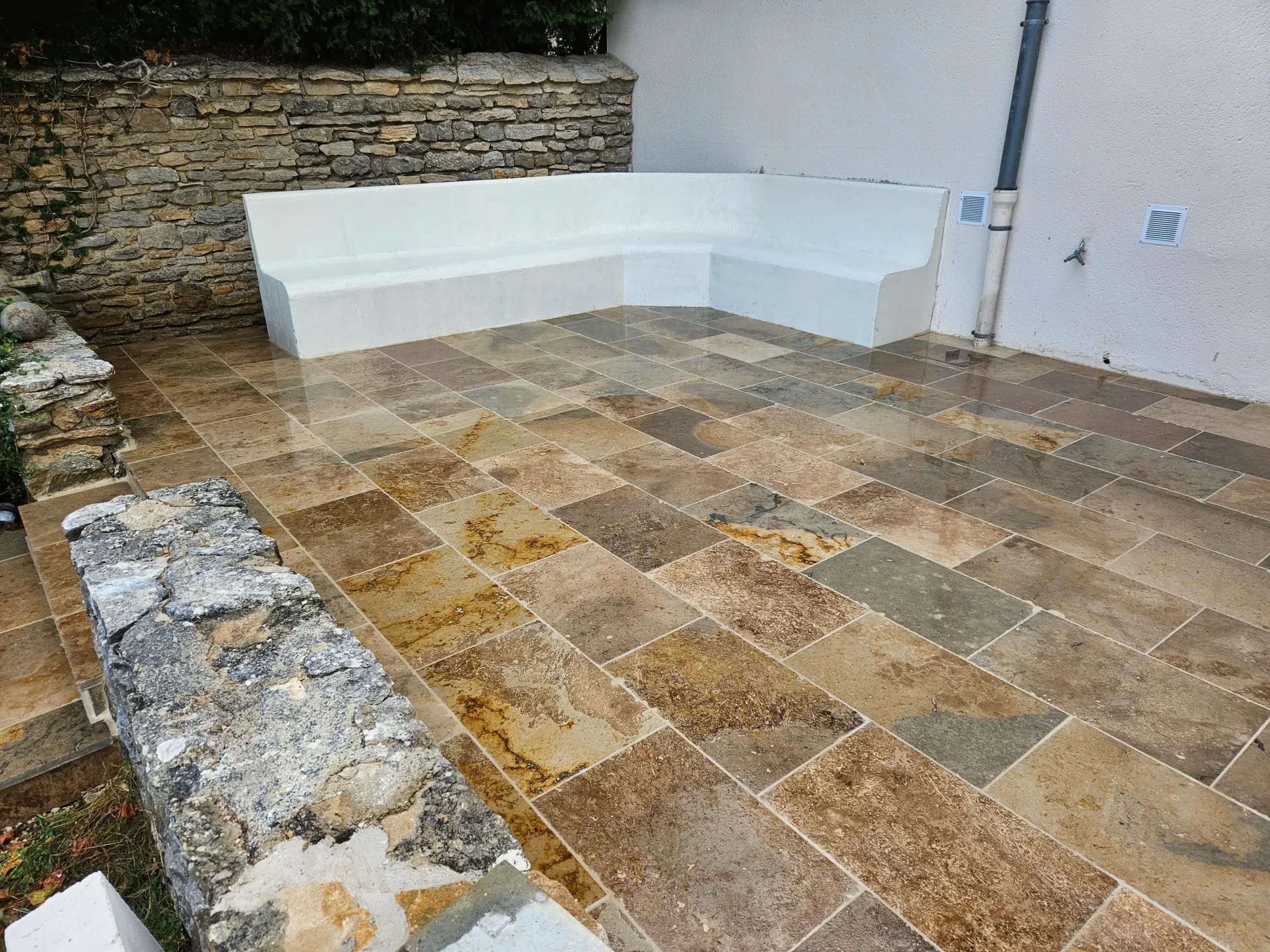 Terrasse dallée en pierre naturelle avec banquette maçonnée le long d'un mur en pierre – Hortiplan Paysagiste