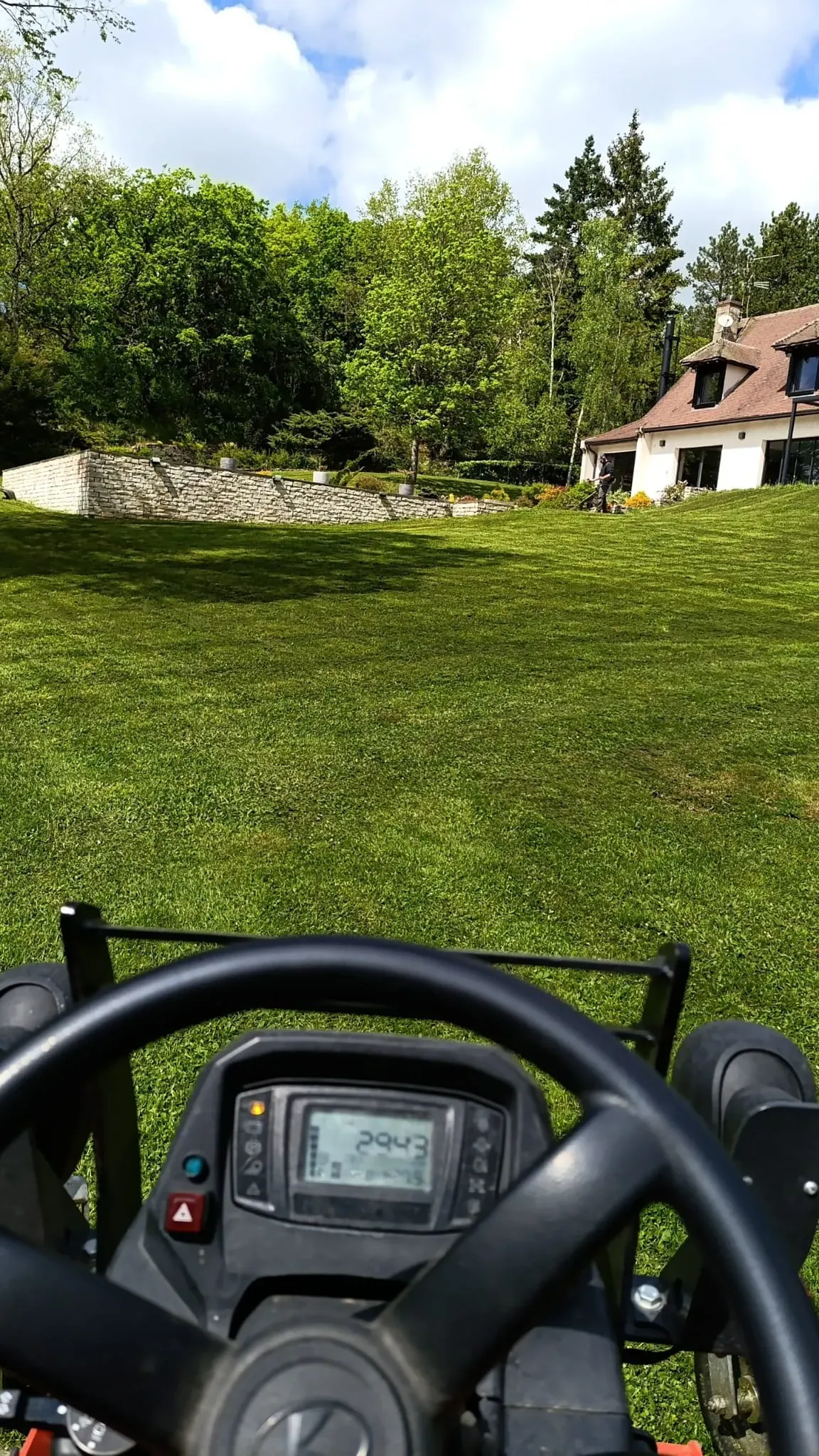 Tonte d'une grande pelouse au tracteur tondeuse vue depuis le poste de conduite – Hortiplan Paysagiste