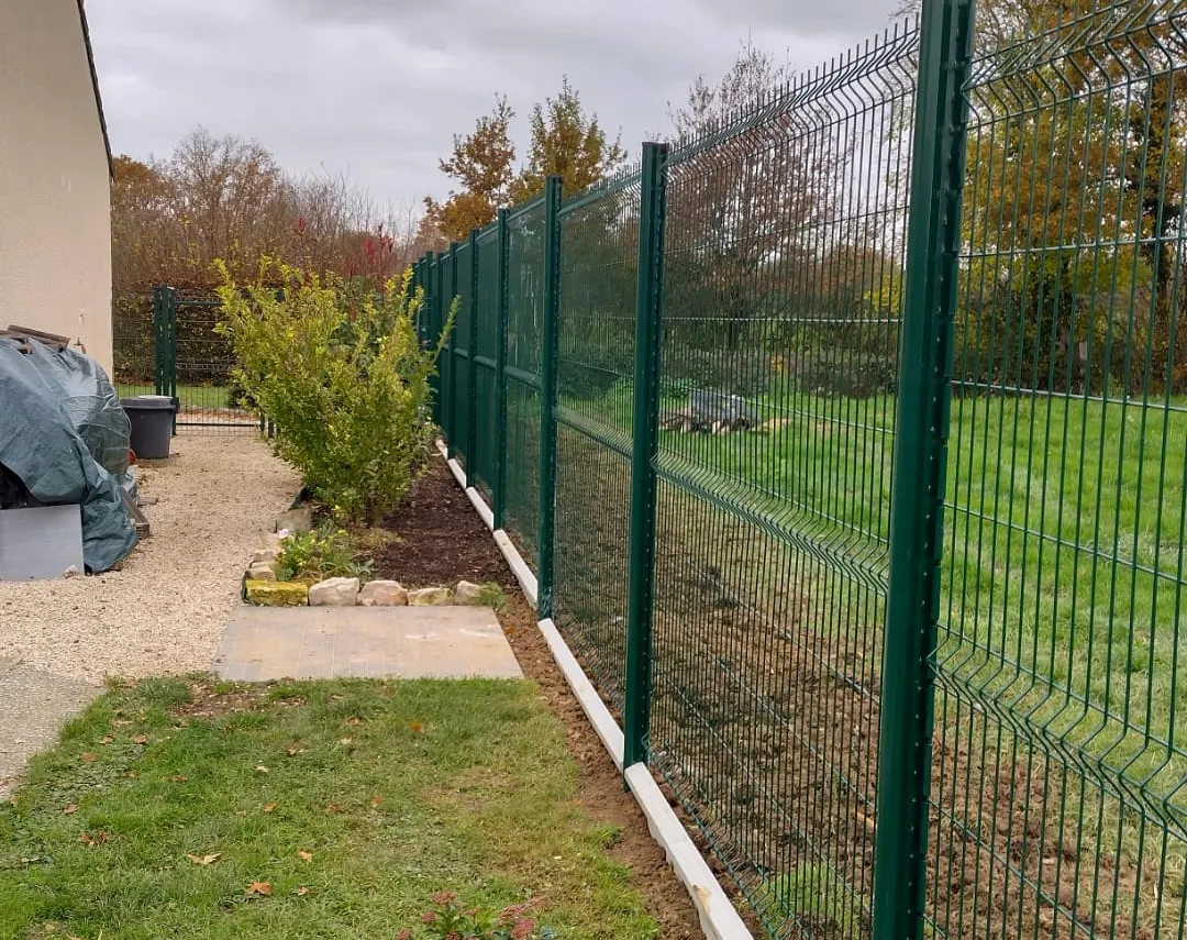 Clôture en panneaux rigides verts posée le long d'une allée en gravier et d'une haie – Hortiplan Paysagiste